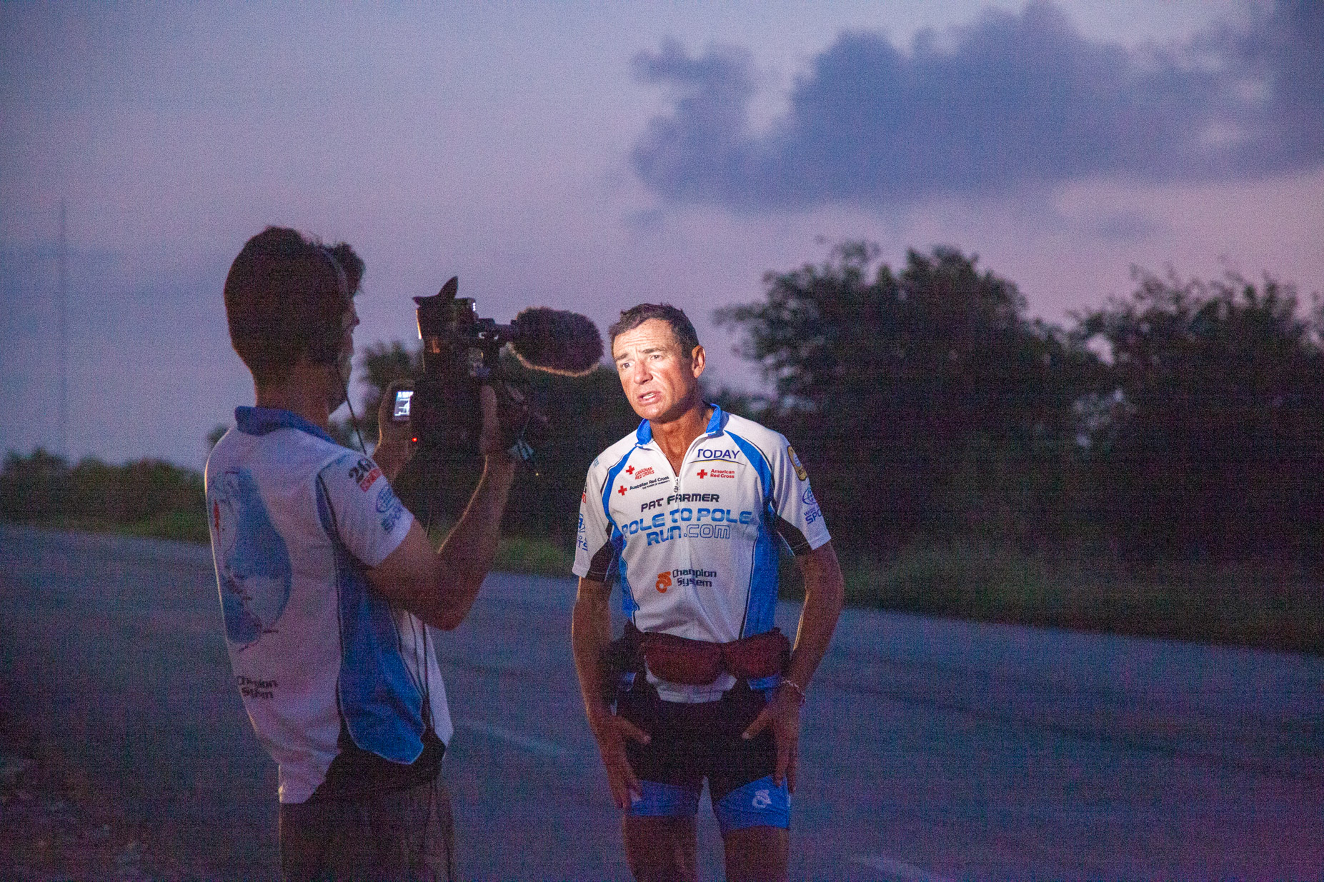 Ultra athlete Pat Farmer on morning report and camera man Juan Femat. Morning report on the roads of Tamaulipas for the project Pat Farmer Pole to Pole Run. American Continent. Juan Femat Media.